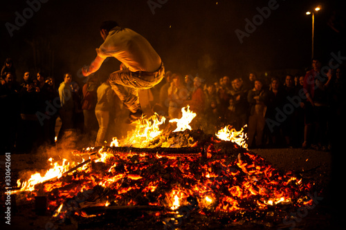 Jóvenes saltando el fuego en las hogueras de San Juan en Pamplona photo