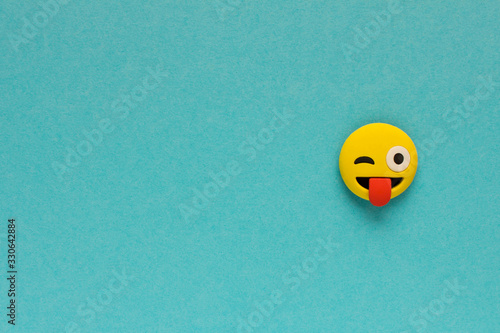 Yellow funny smiley face on blue background. Positive mood concept.