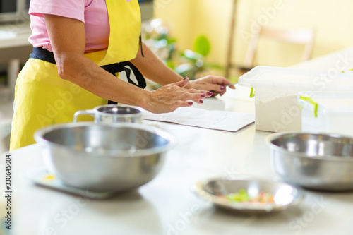 The cook is studying the recipe before cooking