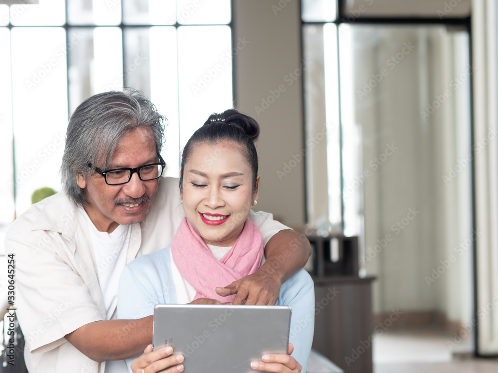 Senior Couple Asian Using Digital tablet in Coffee shop. Technology Communication and lifestyle with Copy space Senior Couple Asian Using Digital tablet in Coffee shop. Technology Communication and lifestyle with Copy space