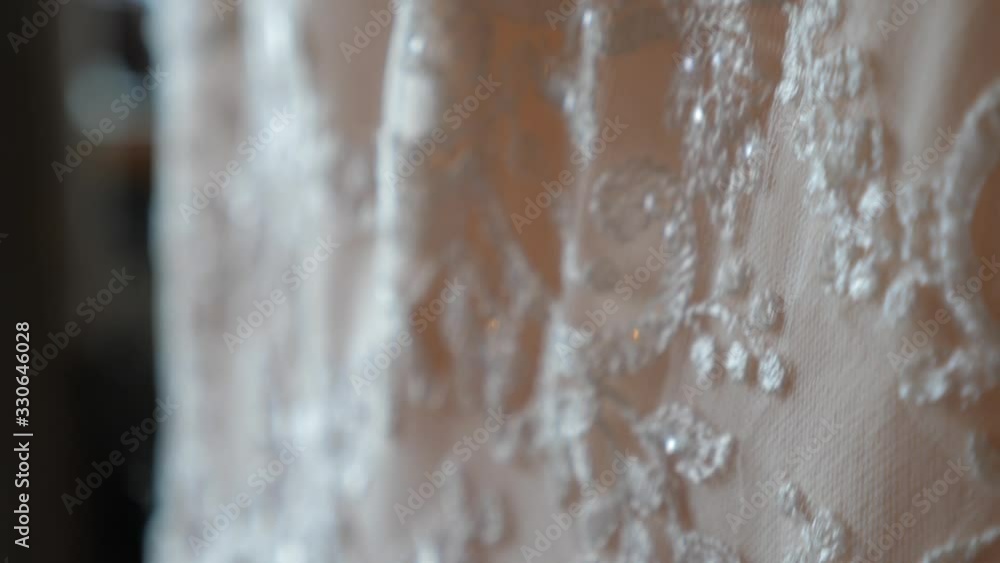 Close up shot of the embroidery on the beautiful white wedding dress. Wedding ceremony traditional formalwear for the bride Close up shot of the embroidery on the beautiful white wedding dress. Wedding ceremony traditional formalwear for the bride