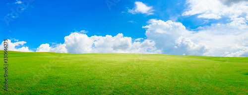 Green grass field and blue sky with white clouds,panoramic view.