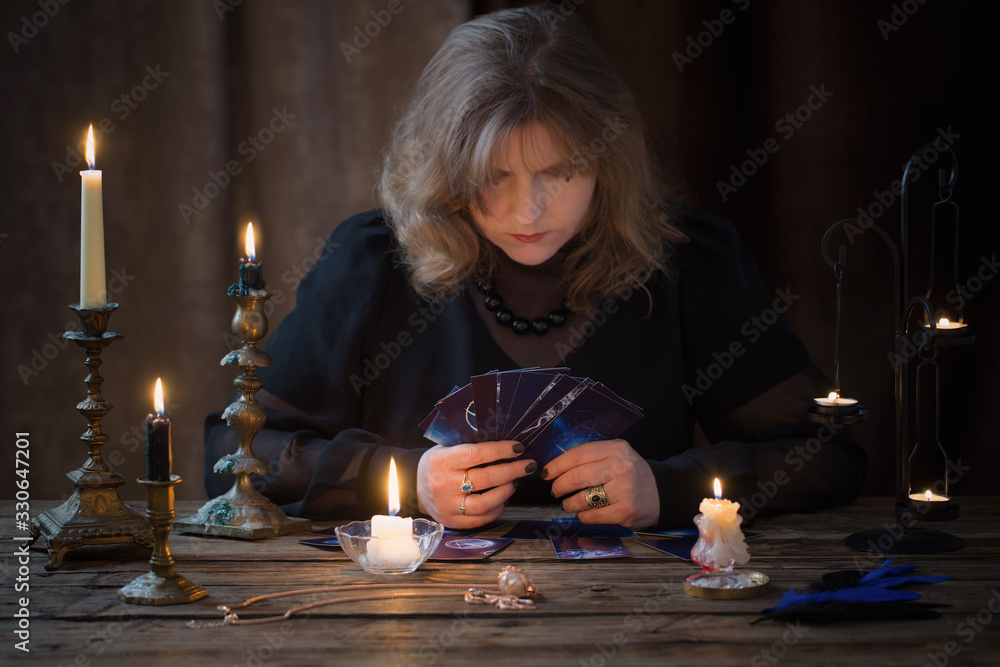 mature woman guessing with cards on dark background mature woman guessing with cards on dark background