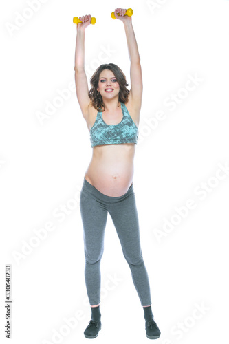 Pregnant woman training with dumbbells to stay active. Pregnant woman practicing fitness and working out during pregnancy Slim pregnant woman is engaged in fitness. Isolated white background.