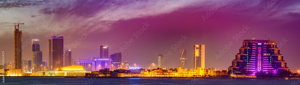 Beautiful view of Manama city skyline with dramatic clouds after sunset, Manama, Kingdom of Bahrain.