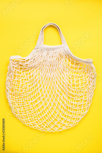 Reusable mesh shopping bag on yellow background. Eco friendly zero waste concept