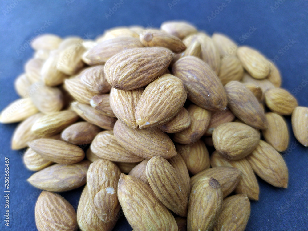 Fototapeta premium some fresh healthy almonds put on black background