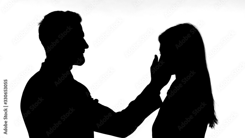 The Silhouette of Man Slapping Woman Against White Background