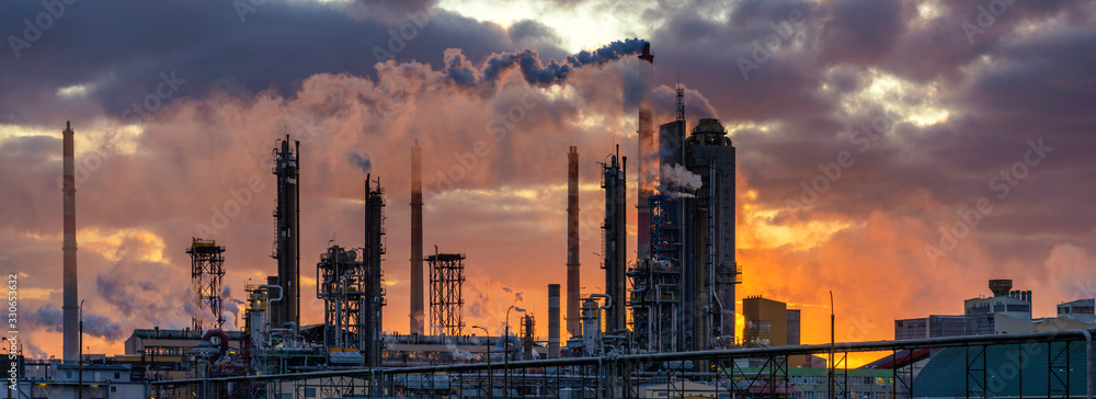 chemical plant at sunrise. Smoke and pollution illuminated by the rays of the rising sun - obrazy, fototapety, plakaty 