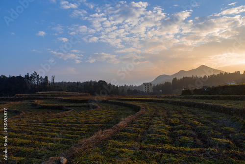 The countryside at dusk, the hazy mountains and the yellow fields