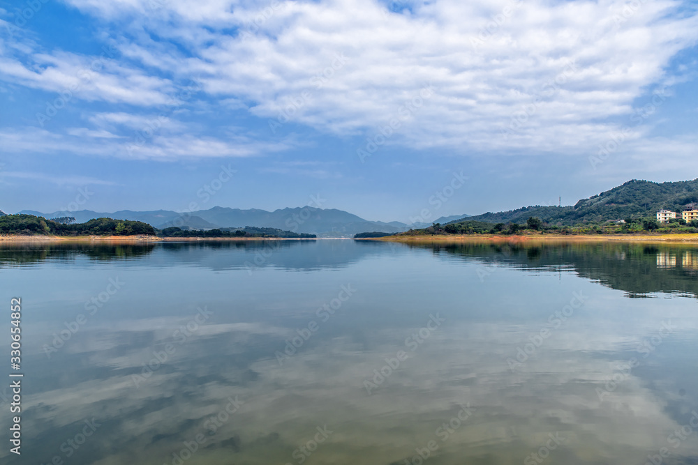 The reservoir under blue sky and white clouds and its ecological environment