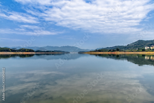 The reservoir under blue sky and white clouds and its ecological environment