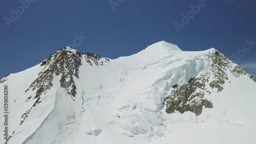 High altitude panorama, dazzling snow mountain summit towering at clear blue sky