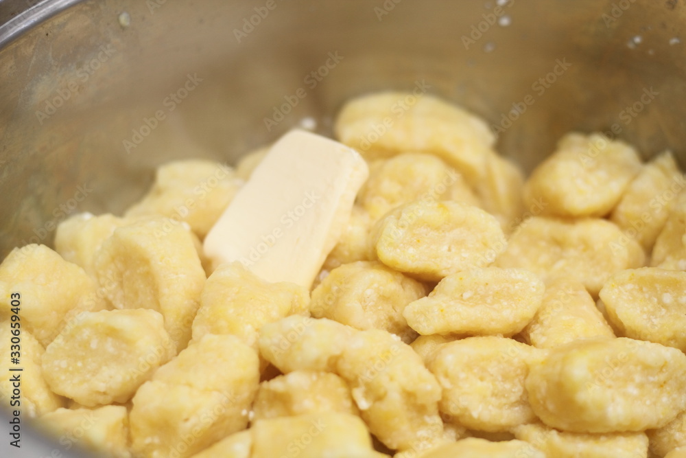 Gnocchi being prepared. Adding butter into cooked dumplings. Dough dumplings with cheese. Gnocchi being prepared. Adding butter into cooked dumplings. Dough dumplings with cheese.