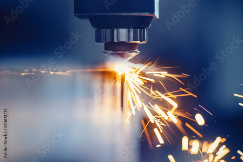 CNC gas cutting metal sheet, sparks fly. Blue steel color, modern industrial technology photo