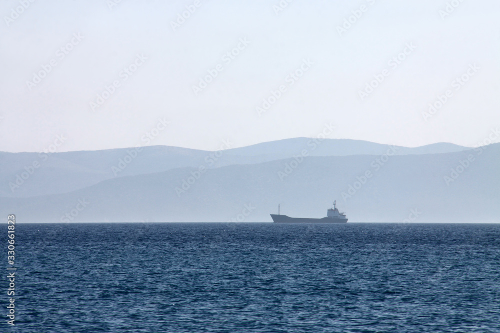 Ein Frachtschiff am Horizont auf dem Meer