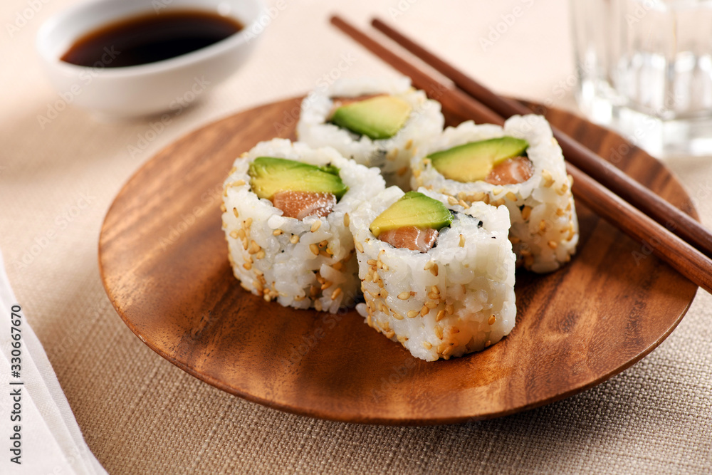 Four traditional uramaki sushi on circular tray