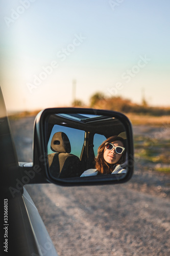 gorgeous woman in sunglasses reflection in car mirror on sunset © phpetrunina14