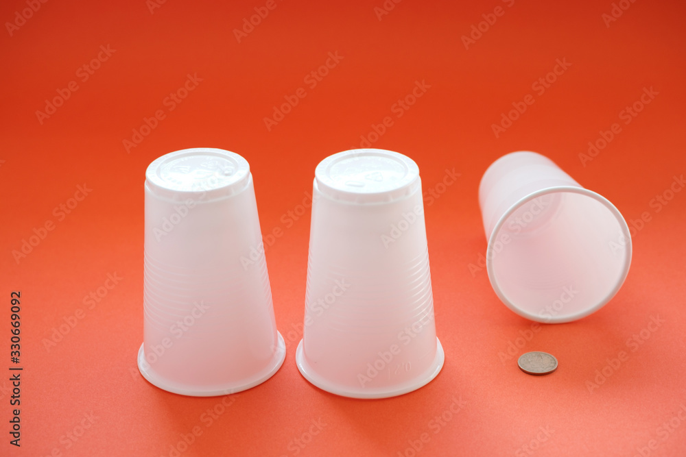 three plastic looms under one of them is a coin three plastic looms under one of them is a coin