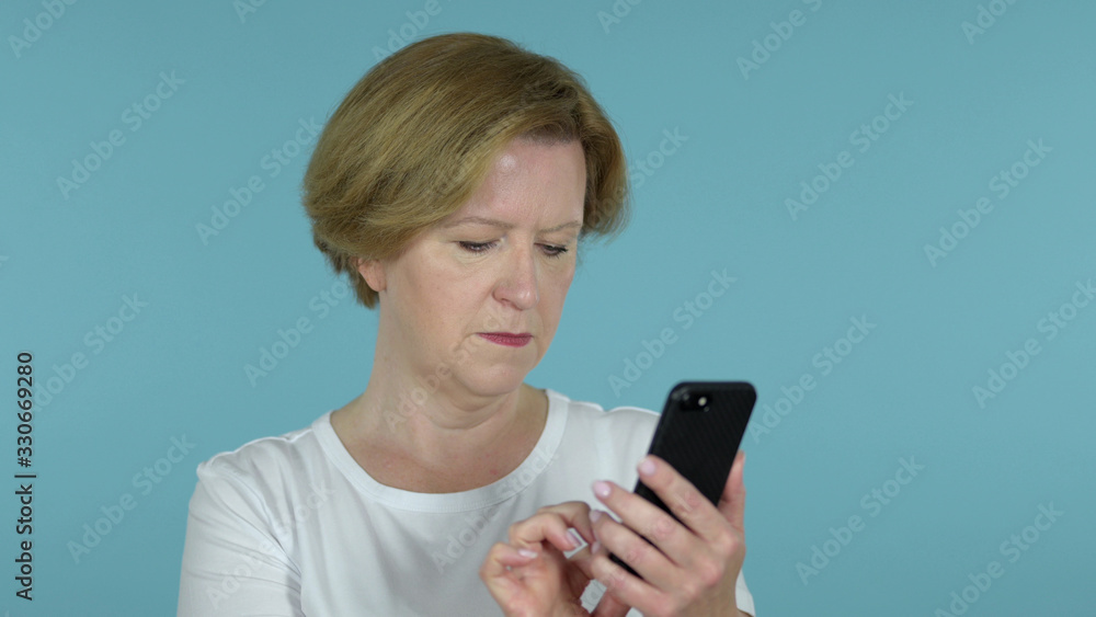 The Old Woman Browsing Smartphone Isolated on Blue Background The Old Woman Browsing Smartphone Isolated on Blue Background