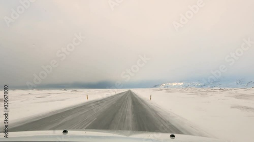 Driving in icelandic winter. Blowing snow across the road. Difficult driving conditions in winter season in Iceland. Icelandic route troubles. Icelandic safety driving.