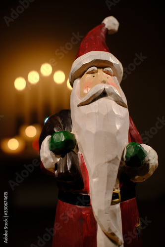 santa claus decoration in front of candle lights with room for copy