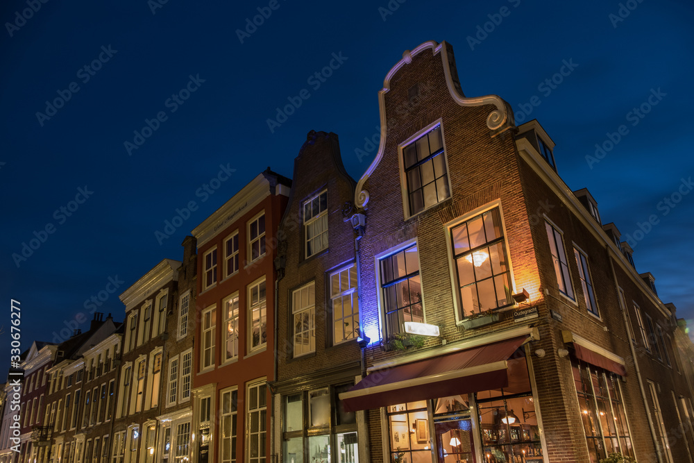Utrecht canal house facades illuminated at night 