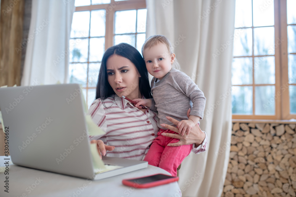 Mom busy working, daughter interfering, looking for attention Mom busy working, daughter interfering, looking for attention