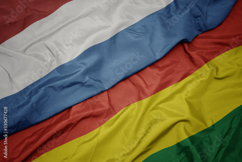 waving colorful flag of bolivia and national flag of luxembourg.