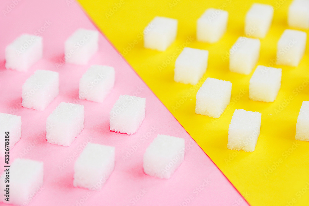 small pieces of white natural refined sugar on a pink background small pieces of white natural refined sugar on a pink background