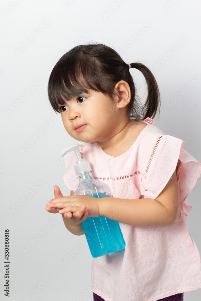 Asian girl using alcohol antiseptic gel for cleaning hands to prevent against infection of Covid-19 outbreak.