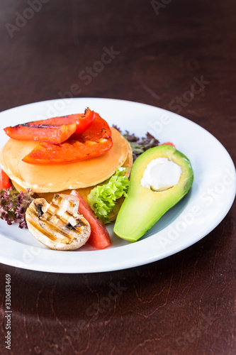 Vegetarian pancakes with grilled vegetables. Mushrooms  peppers and avocados. Decorated with grapefruit and salad. Close up