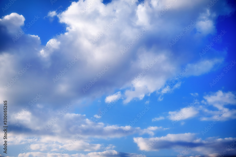White cumulus clouds in clear weather. The sky on a sunny summer day. Background clouds on blue sky