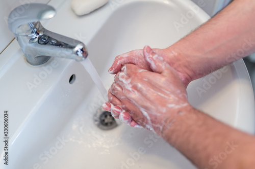 Hygiene concept. Washing hands with soap under the faucet with water, washing hands with soap over sink in bathroom. Hygiene. Cleaning Hands. Washing hands on sink.