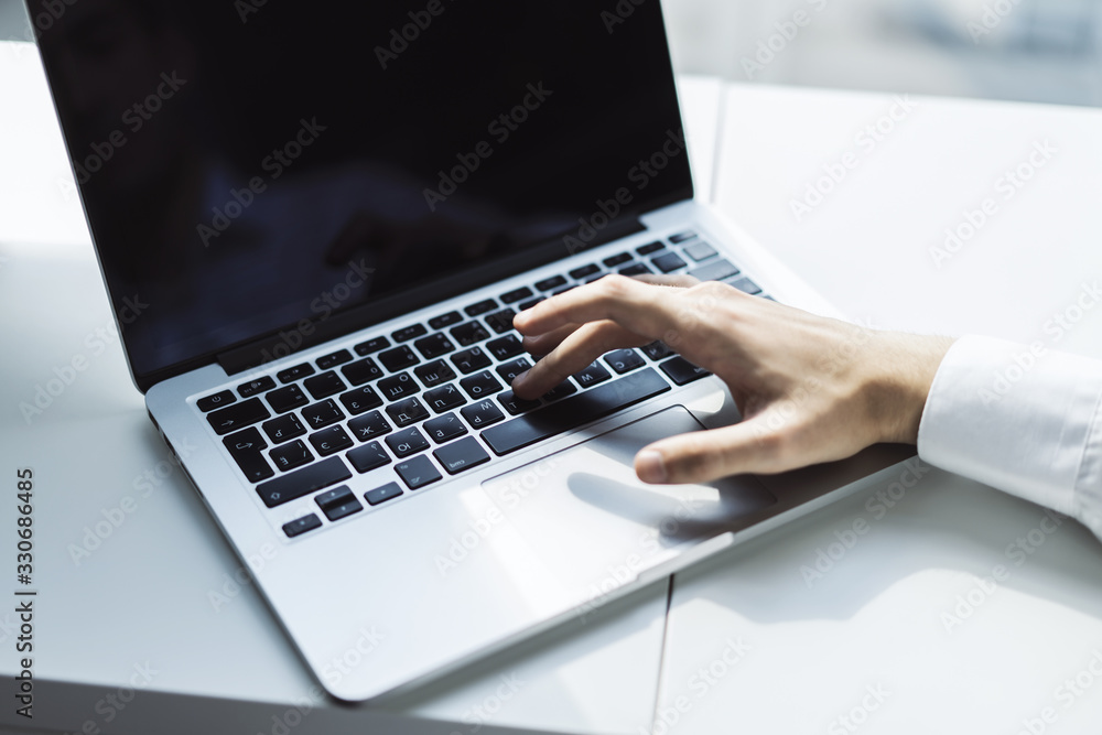 Man hands typing on laptop keyboard in sunny office, business and technology concept. Close up Man hands typing on laptop keyboard in sunny office, business and technology concept. Close up
