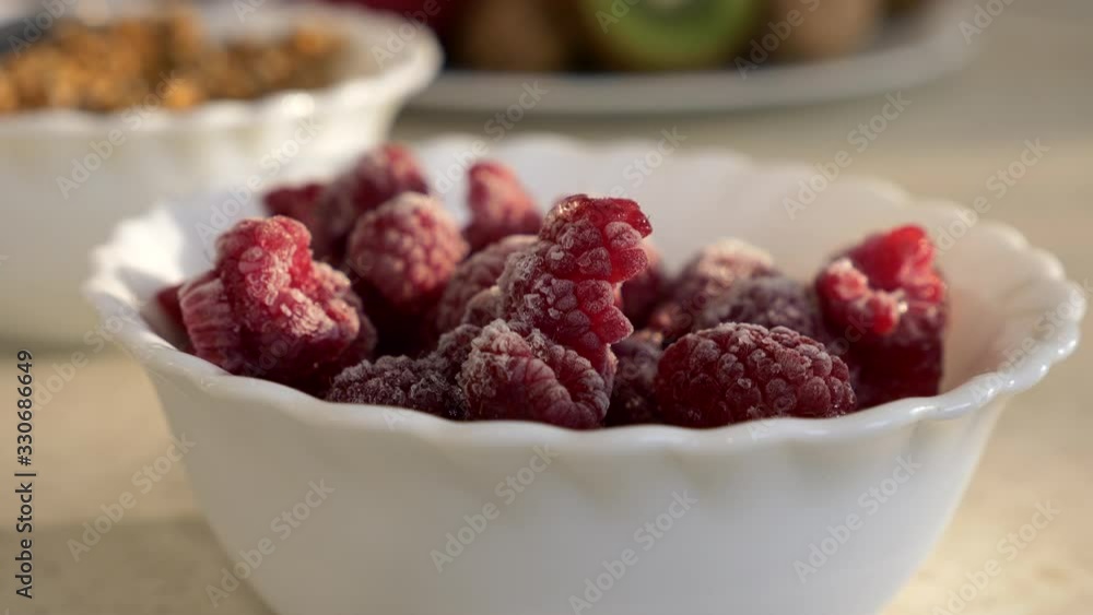 Close-up Frozen Raspberries on Kitchen Countertop. Morning Evening Sunshine through Window. 2x Slow motion, 0.5 speed 60 FPS Close-up Frozen Raspberries on Kitchen Countertop. Morning Evening Sunshine through Window. 2x Slow motion, 0.5 speed 60 FPS