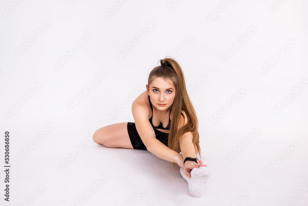 Fitness woman doing exercises on a white background. Athletic girl trains Fitness woman doing exercises on a white background. Athletic girl trains