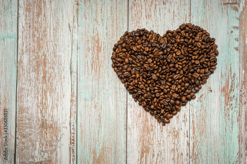 roasted coffee beans laid out in the shape of a heart on an isolated background © Nemo67