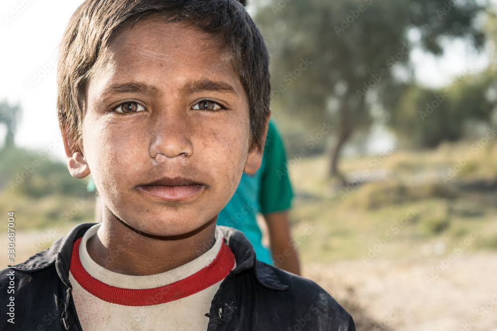 closeup of a poor staring hungry orphan boy in a refugee camp with sad expression on his face and his face and clothes are dirty and his eyes are full of pain closeup of a poor staring hungry orphan boy in a refugee camp with sad expression on his face and his face and clothes are dirty and his eyes are full of pain