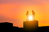 Silhouette of Business engineer man with clipping path handshake on cargo container evening sky sunset background, Success and happiness team concept