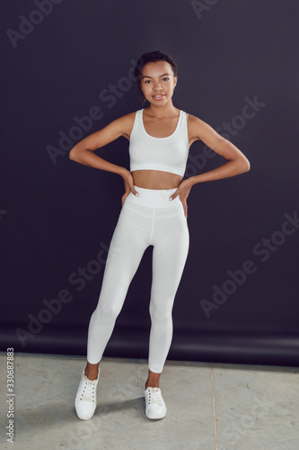 Young african american woman in white blank leggings and a crop top. Mock-up.