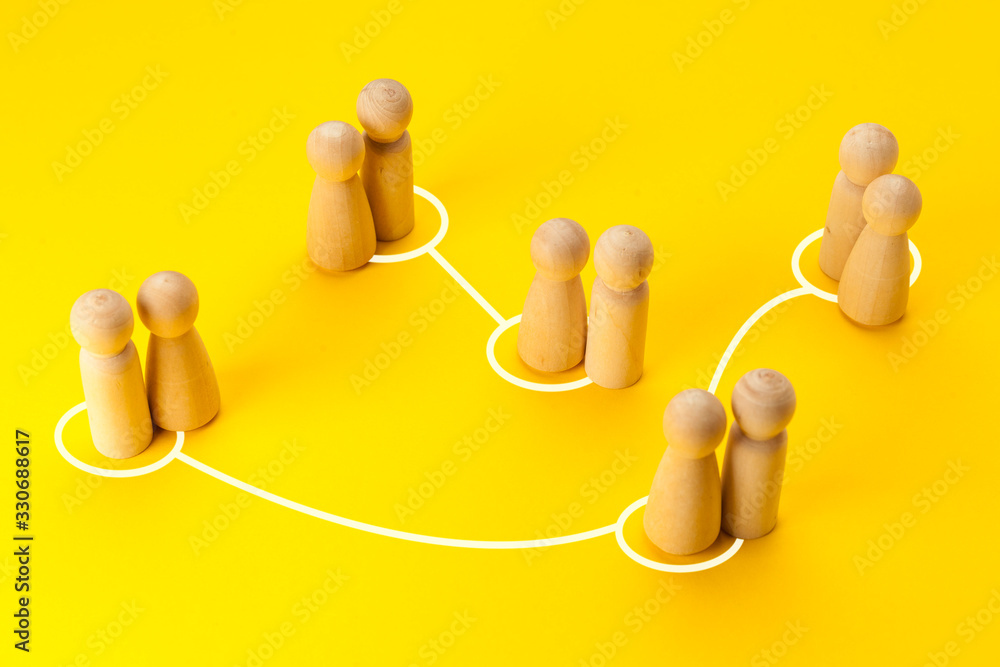 Concept of infidelity and betrayal (treason) in family or married couple. Wooden figures with lines as symbol of the relationship between man and woman on yellow background.