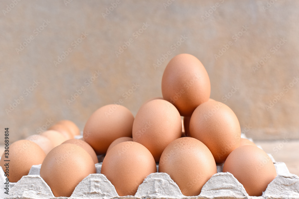 Egg, Chicken Egg. Close-up view of raw Brown chicken eggs in egg box on Cement floor background. Selected focus Egg, Chicken Egg. Close-up view of raw Brown chicken eggs in egg box on Cement floor background. Selected focus
