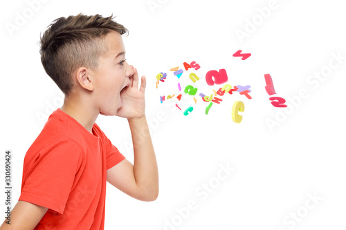 Young boy in bright red T-shirt shouting out alphabet letters. Speech therapy concept over white background. photo