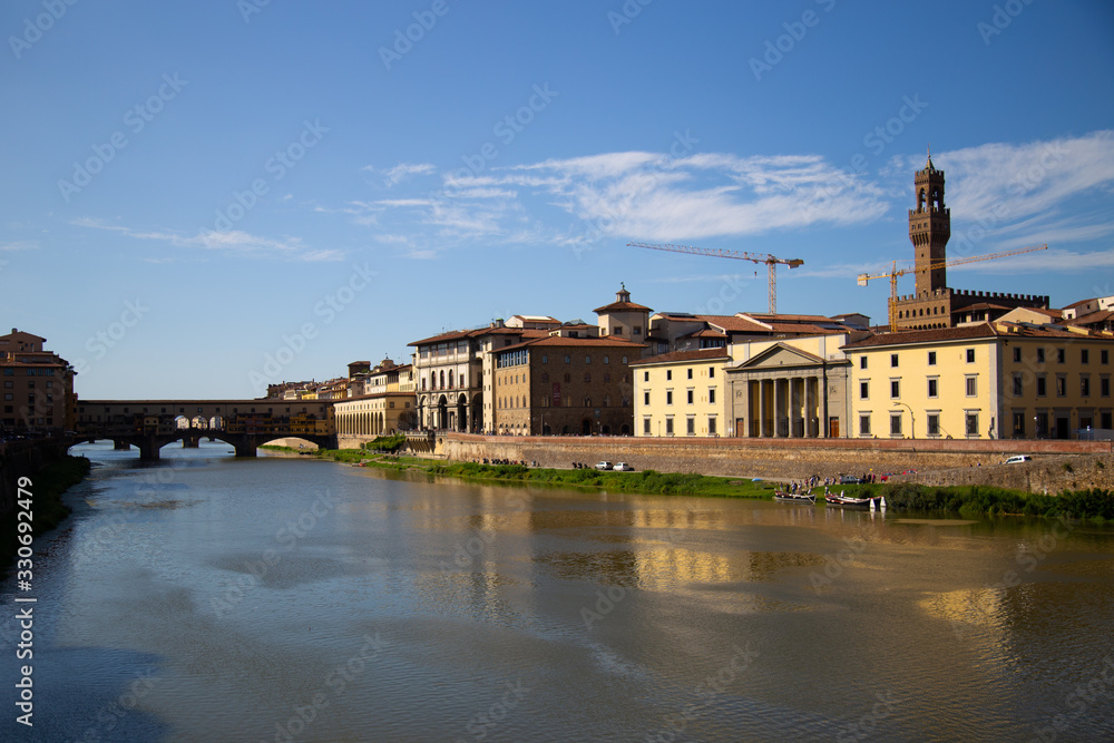 FLORENCE, ITALY - September, 2019: Italian traditional houses and architecture over Arno river with blue sky in Florence, Italy.