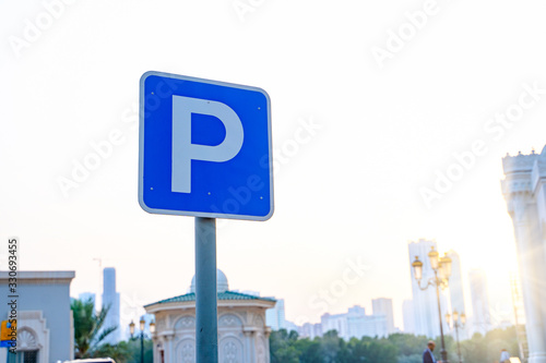 Parking traffic road sign on the right side and background of blue sky. Paid parking sign. Blurred background