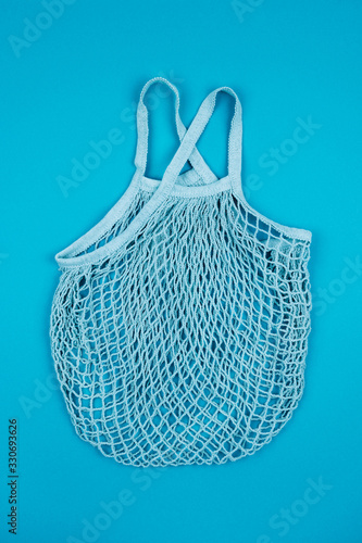 Empty reusable string eco bag for shopping on blue background. Zero waste and plastic free concept. View from above.