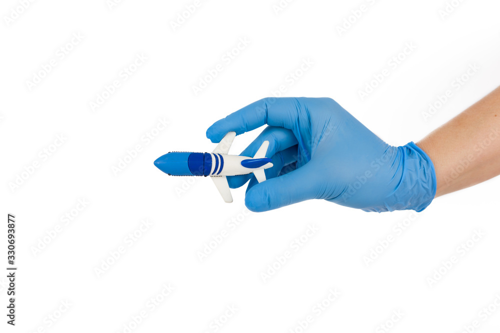 Hand with medical protective gloves and plane on white background. Cancellation flight and travel warning concept. Hand with medical protective gloves and plane on white background. Cancellation flight and travel warning concept.