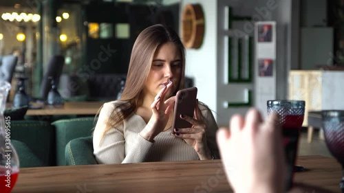 girl sitting in coffee shop playing mobile phone for social media on vacation time