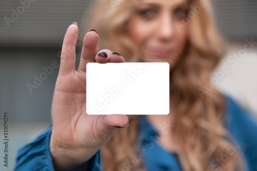 Blonde beautiful woman is holding an empty card in her hand